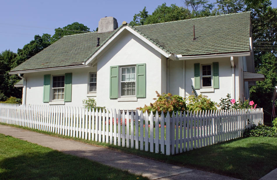 Dom z zielonym dachem i białymi oknami